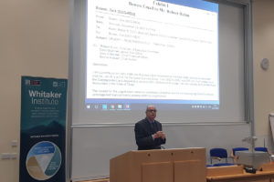 Photo of Richard M Bowen speaking at The Whitaker Institute with a slide of his 2007 email to Rober Rubin.