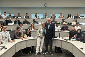 Lisa Shatz and Richard M. Bowen stand with Cohort MBA students in a UT Dallas classroom.