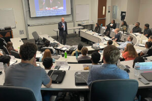 Image: Richard M. Bowen speaking to a room full of MBA students at UTD.