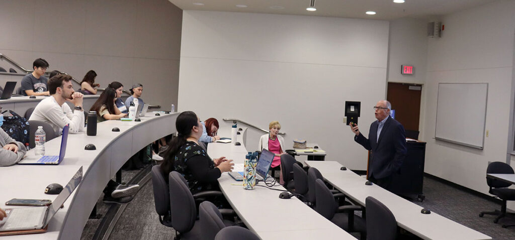 Photo of Richard M. Bowen speaking to students in a classroom.